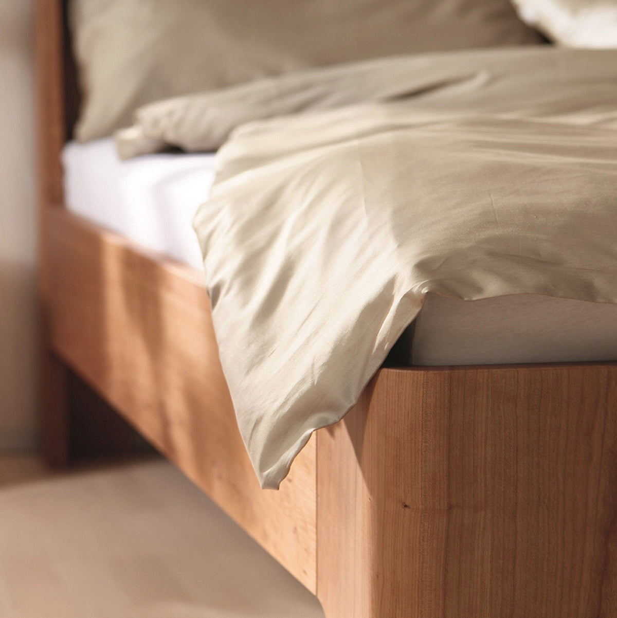 Fußteil-Detail vom Bett GIRO mit Komforthöhe in massivem Kirschbaum